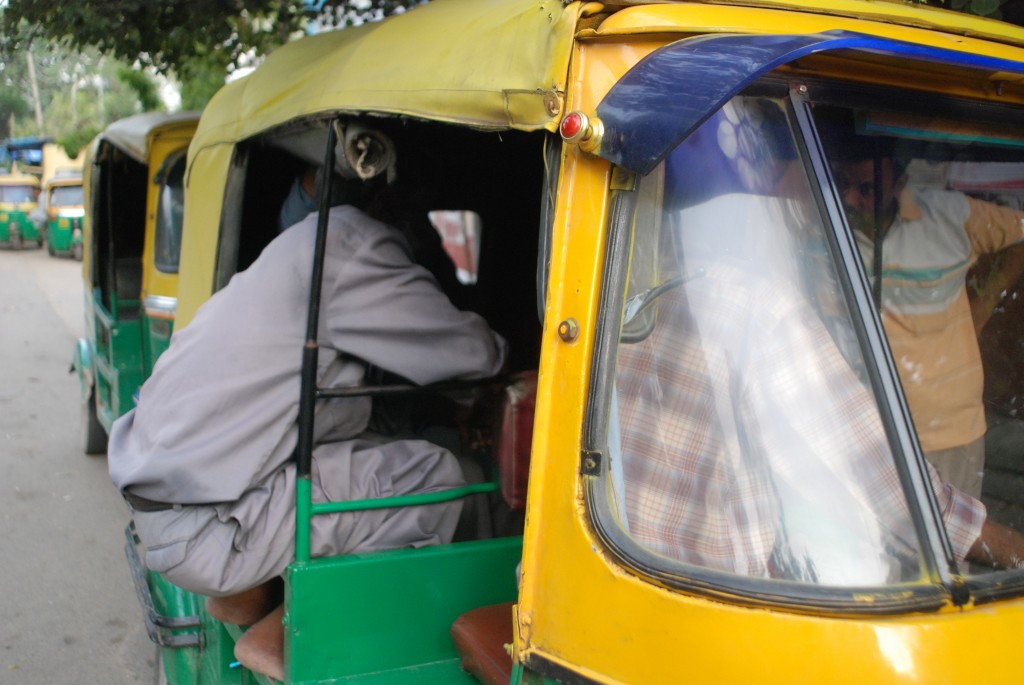 A handful of auto rickshaw drivers hundled inside one cab.